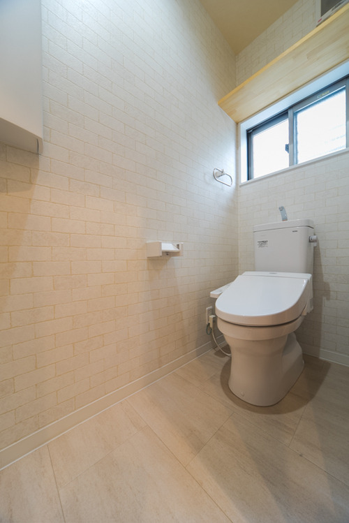 1階のトイレは白を基調に、壁はレンガ調、床はストーン調