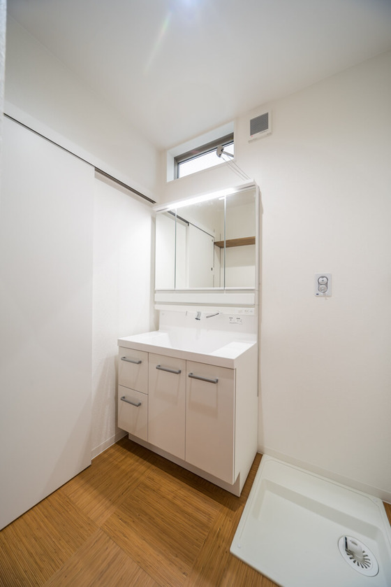 洗面室壁と天井は白色で統一。床は『籐』のフロアタイルを選ばれ、清潔感のある落ち着いた雰囲気に仕上がりました