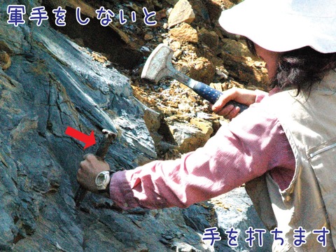 タガネとハンマーで岩石を割る様子