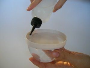 スポイト状の容器で水を台座底の穴から流し込みます。 スポイト状の容器で水を台座底の穴から流し込みます。薬局などで精製水をお求めになることをお勧めします。最後に一滴台所用の液体洗剤を入れてください。パウダーが水によく馴染み綺麗に舞うようになります。