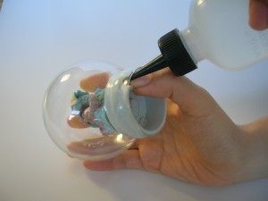 キャンプを嵌め水を入れます。 ゴムキャップと中身が外れないようにゆっくりゴムキャップをはめていきます。ガラスを割らないように無理に力を加えないようにします。ゴムキャップを完全にはめることができたら、一部をつまんで隙間をあけます、隙間からスポイト状の容器で水を入れます。最後に行ってき台所用洗剤を入れると水と粉が馴染みます。空気がまだ入っているようでしたら時間をかけゆっくり水を入れて空気を追い出します。