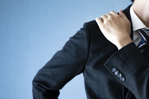 肩を凝らす男性ビジネスマン