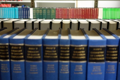 大型本棚に並べられた青い沢山の辞典