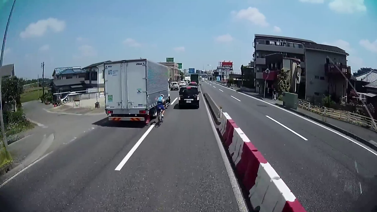 トラックが自転車に幅寄せし接触