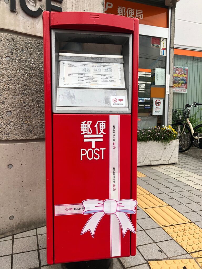 赤いポストに白のリボンでラッピング を見つけた 郵政創業150年 宝塚コミパ通信