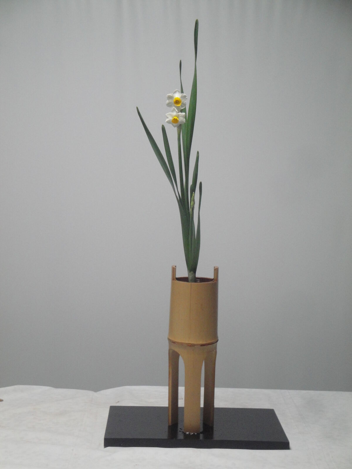 水仙の一種生けを鼎（かなえ）に井桁で活け,銅器の一文字に又木で活け