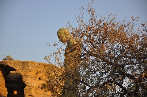 下を向く木の向こうの銅像650