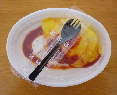 テイクアウトしたラケルのチキンライスのオムライスとスプーンの写真