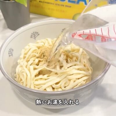 耐熱容器に移したどん兵衛の麺に熱湯をかける様子