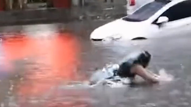 中国、洪水で冠水した道路で水泳する女子、走ってきた車にひかれる！