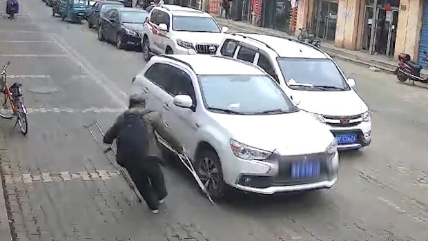 中国、当たり屋のおじいさん、松葉杖を車にちょこんと当てて大げさに倒れる