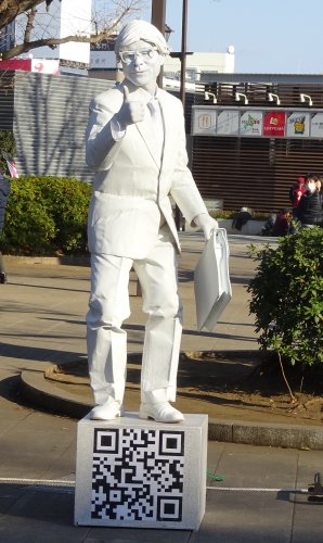 全身を真っ白に塗った大道芸人のパントマイム「人間彫刻 白リーマン」