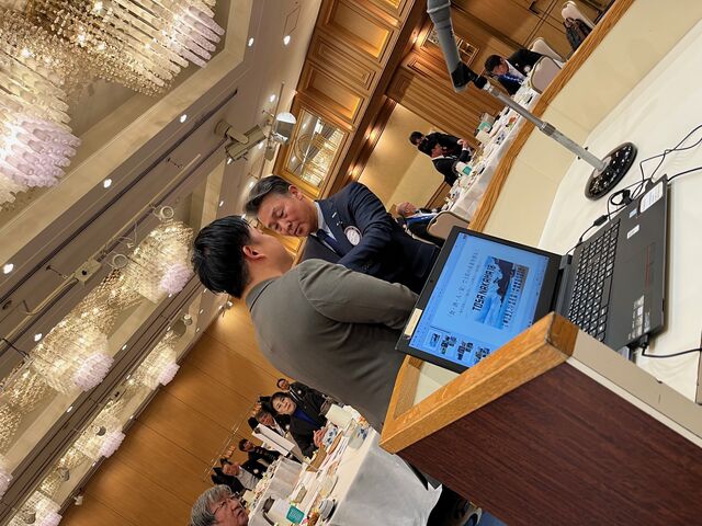 写真8 須江社長にバッジを