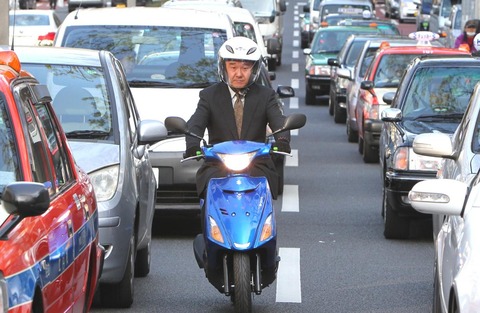 車と車の間すり抜けていくバイク