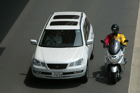 すり抜けさせたくなくて左を塞ぐ自動車