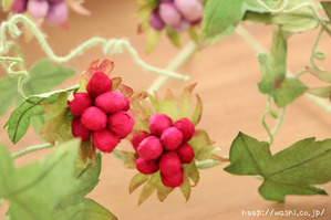 グリーンの実をつけた和紙製の植物を使ったモダンな一輪挿しパネル(赤や紫の実)