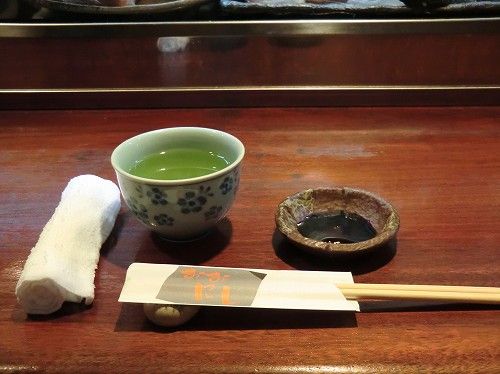 【焼とり・活魚・季節一品料理 おおにし】入店すると、店内満席。ちょうどお会計中のお客さんが居て、片付けを待ち、カウンターに着席。お茶とオシボリが置かれた。店内は他に、小上がりの堀座敷に５卓。 (2)