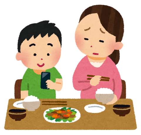 食事中にスマートフォンをいじる子供