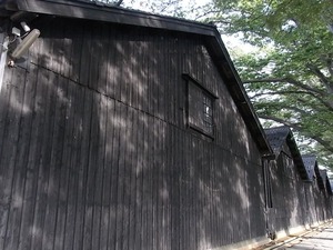 山居倉庫 酒田夢の倶楽 黒壁の倉庫群の倉庫壁に日差しが当たる
