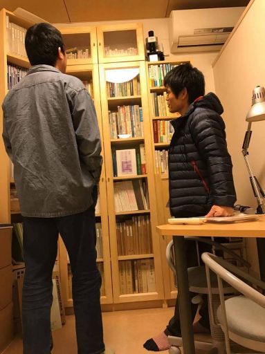 養気院の問診室の本棚の前で