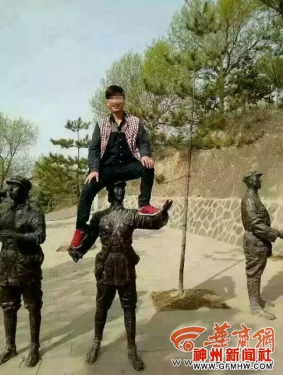 彫像に座った中国人観光客